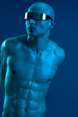 Powerful man with futuristic sunglasses, showcasing a striking blue light background, creating a...