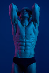 Muscular man posing in dramatic lighting, showcasing toned abs and strong physique, emanating...