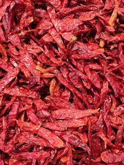 Fototapeta premium Close-up of a pile of air-dried red chilies. Hot and spicy dried red chilies.Primer plano Montón de fondo de chiles rojos secados al aire. Chiles rojos secos calientes y picantes.(16)