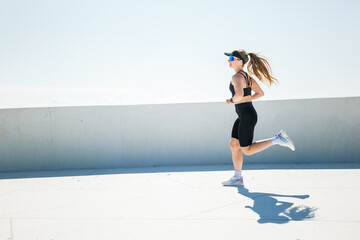 Jogging on a rooftop under a clear sky in stylish activewear