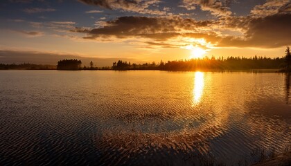 Naklejka premium golden reflections shimmer across tranquil water at sunset creating a serene landscape