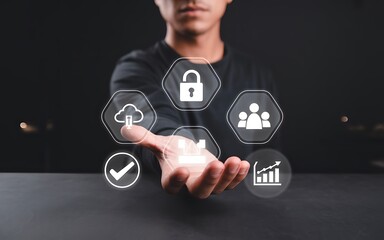 Man holding holographic icons for business technology concept, including cloud computing, data security, team collaboration, and performance analytics for digital transformation strategy.