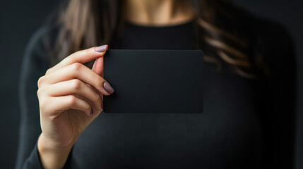 Naklejka premium Close up of womans hand holding blank black card 