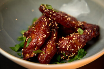 Deliciously Glazed Chicken Wings Garnished with Fresh Herbs and Toasted Sesame Seeds, Perfect for Any Appetizing Dish or Party Snack
