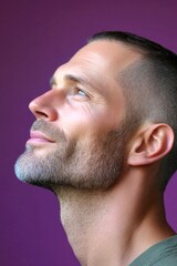 Obraz premium Visual idea visual creative design of style for aging men. Purple solid background. A stylish and glowing male with a relaxed aura. Chic men's buzz cut haircut - midlife white man with hair.