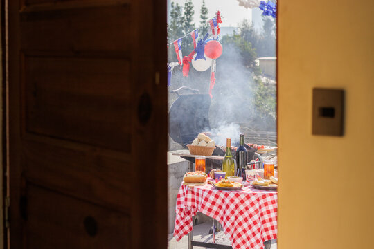 Chilean Independence Day: barbecue scene viewed from doorway with decorated table