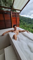 Handsome Man Relaxing on Holiday with Lush Green Valley and Misty Mountain Views in Chiang Mai, Thailand