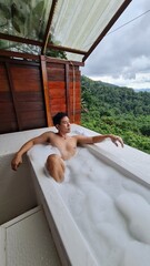 Handsome Man Relaxing on Holiday with Lush Green Valley and Misty Mountain Views in Chiang Mai, Thailand