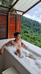 Handsome Man Relaxing on Holiday with Lush Green Valley and Misty Mountain Views in Chiang Mai, Thailand