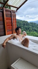 Handsome Man Relaxing on Holiday with Lush Green Valley and Misty Mountain Views in Chiang Mai, Thailand