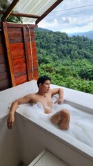 Handsome Man Relaxing on Holiday with Lush Green Valley and Misty Mountain Views in Chiang Mai, Thailand