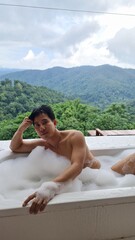Handsome Man Relaxing on Holiday with Lush Green Valley and Misty Mountain Views in Chiang Mai, Thailand