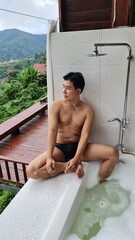 Handsome Man Relaxing on Holiday with Lush Green Valley and Misty Mountain Views in Chiang Mai, Thailand