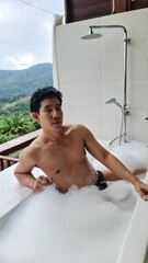 Handsome Man Relaxing on Holiday with Lush Green Valley and Misty Mountain Views in Chiang Mai, Thailand