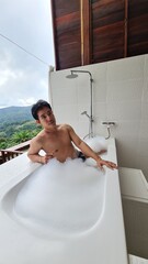 Handsome Man Relaxing on Holiday with Lush Green Valley and Misty Mountain Views in Chiang Mai, Thailand