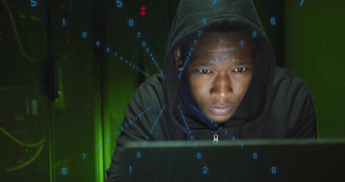 Man seated behind laptop turning head triggered by streaming numeric code overlay in data center