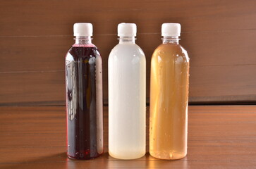 Refreshing colorful beverage bottles for healthy hydration against a warm wooden backdrop offer natural appeal