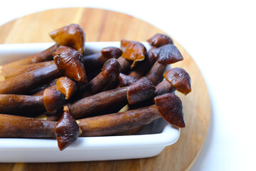 Termite mushrooms with long stems, white tips, and dark brown caps.