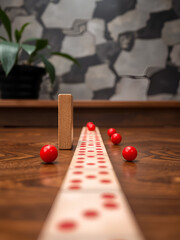 Red Sphere Disrupts Wooden Dominoes Line Sequence Pattern