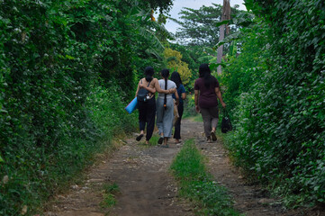 The morning walk continues as the girls maintain a close and unified stride through the lush...