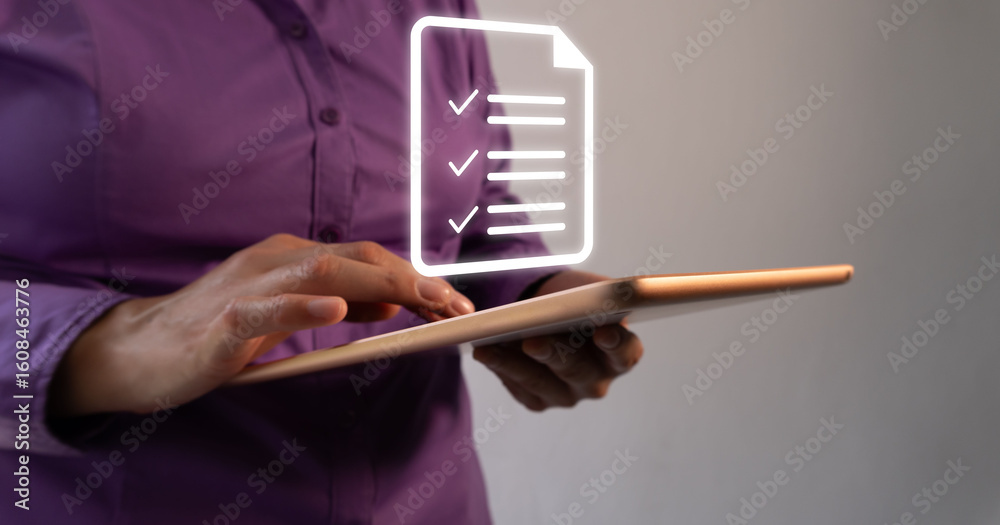Poster business person working on a tablet with a floating virtual icon of a document with several checkmar
