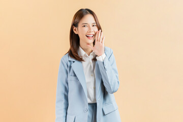 Happy Asian business woman shouting and hands over mouth on beige color background.