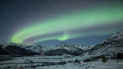 Mountains are lined in snow below aurora borealis in a night sky filled with stars - Powered by Adobe