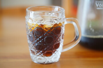 カットガラスのマグカップに注がれたアイスコーヒーが涼やかで透明感ある夏の飲み物を演出している