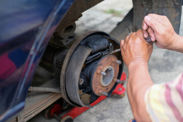 Mechanic works on cars drum brakes