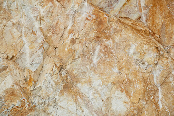 Natural surface of a marble quarry wall with rough textured stone.