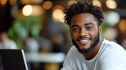 Obraz premium A smiling young man in a casual setting, engaging with technology and enjoying social interaction.