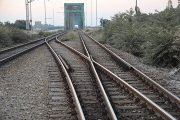 Naklejka premium Railway junction. Perspective of crossing rails, traffic lights and train. Railway tracks, junction of tracks, perspective view. Pancevo bridge. Belgrade, Serbia.