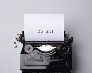 Vintage typewriter with a sheet of paper displaying the words "Do it!