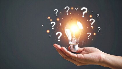 Hand holding glowing bulb surrounded by question marks—symbolizing ideas, inquiry, and innovation
