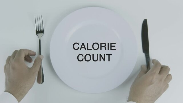Calorie Count written on a plate with a hand holding a fork and knife against a white background, symbolizing nutrition tracking, dietary management, portion control, and healthy eating