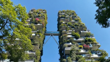 Modern vertical forest residential towers with lush greenery and skybridge under blue sky represent sustainable architecture, eco-living, urban biodiversity, and the future of green residential design
