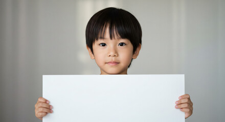 Young boy holding a blank sign.