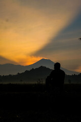 Fototapeta premium Silhouette contemplates mountain sunset glow