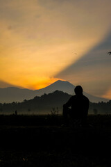 Fototapeta premium Silhouette gazing at sunrise mountain