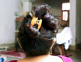 Back View of a Woman&rsquo;s Hair Bun Secured with a Claw Clip Indoors