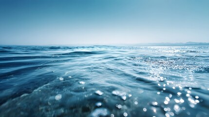 Clear blue water with sparkling sunlight reflecting on the surface.