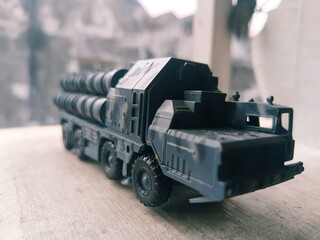 Close-up of a military missile launcher toy truck with cylindrical tubes, ideal for defense or...