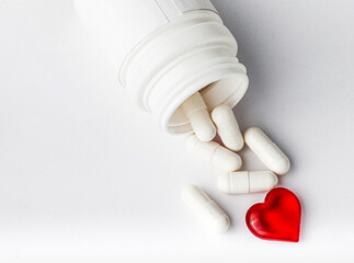 a fallen jar with spilled medicine capsules on the table. copy space
