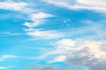 A bright blue sky background with a few wispy clouds.