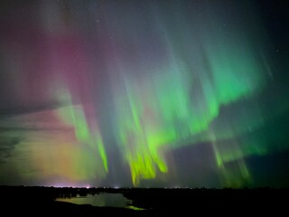 colorful northern ligths over the missouri river in northeast montana with a small town 