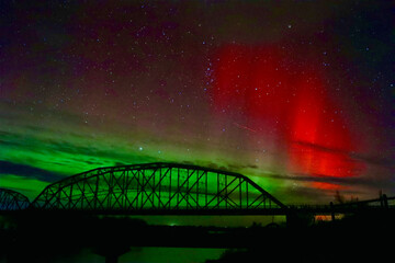red flash aurora borealis truss bridge at night 