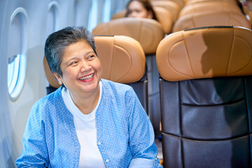 Scene of smile face by senior asian passenger travel inside airplane for travel business trip.