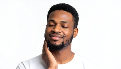 A young Black man with his eyes closed, gently touching his chin, smiles serenely against a white background
