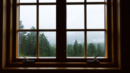 Window with rain on it and a view of the mountains