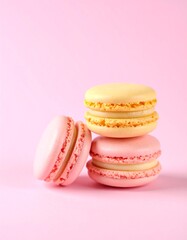 Obraz premium Colorful pink and yellow macarons stacked on a pink background. Bright and vibrant dessert perfect for bakery banners, invitations, or sweet-themed promotions. Copy space for text or branding